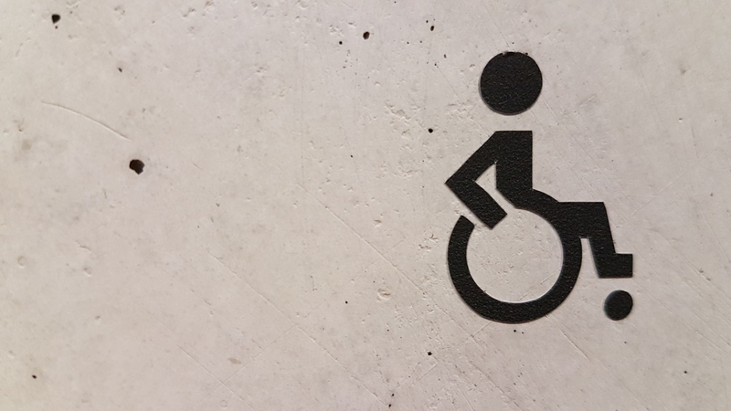 Kørestolsymbol på grå væg