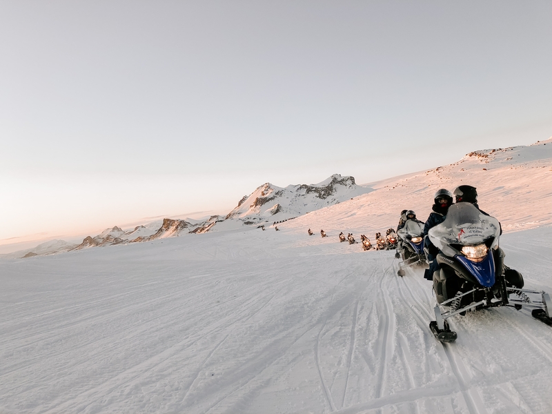 Snowmobiles tracking along an Icelandic snow landscape 