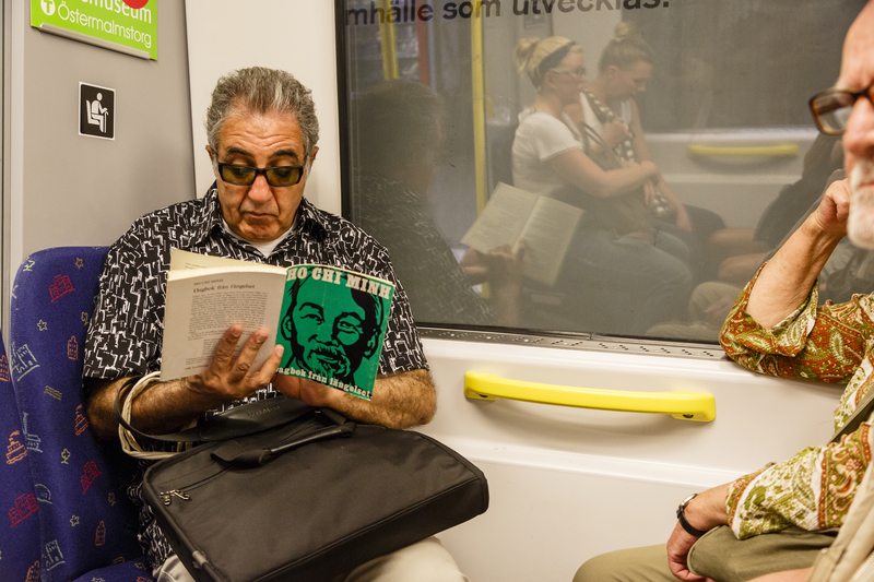 Mand læser bog i tog