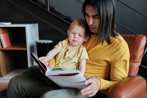 A man reading a book to a child