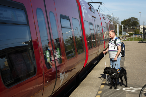 Blind mand med hund ved togstation