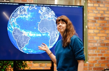 woman pointing at a photo of the globe