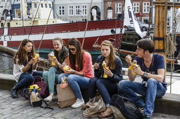 Unge spiser is ved en havn